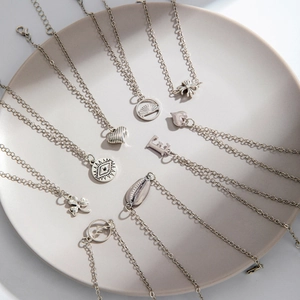 Silver fashion necklace collection with various pendants including heart and shell designs