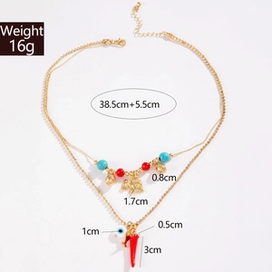 Detailed view of layered bohemian necklace with chili, evil eye, and elephant charms
