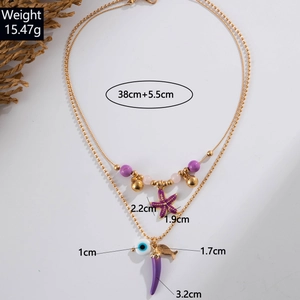 Detail view of layered beach necklace with starfish, evil eye and chili charms