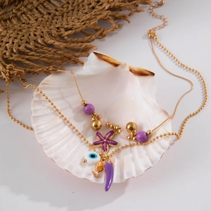 Detail of bohemian gold bead necklace with purple starfish, chili and evil eye charms