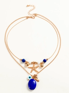 Detail of bohemian layered necklace featuring starfish charm and evil eye pendant