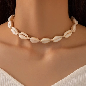 Collier ras de cou bohème avec des perles en coquillage ivoire sur le cou d'un modèle