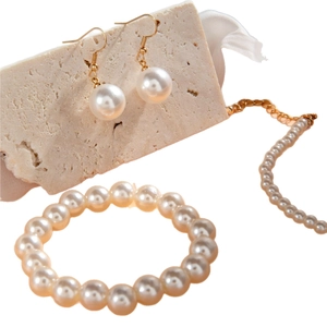 Elegant pearl jewelry set with necklace, bracelet, and earrings on stone pedestals