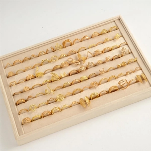 Set di 70 anelli vintage dorati con design a serpente e cuore su espositore beige