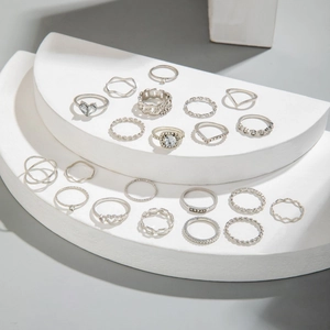 Set di anelli retrò argento con strass e disegni a cuore su piedistallo bianco