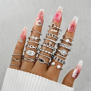 Dettaglio del set di anelli bohémien in argento con motivi a cuore, perla e corona