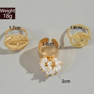 Macro view showing measurements of gold lip ring, pearl cluster, and spiral band set