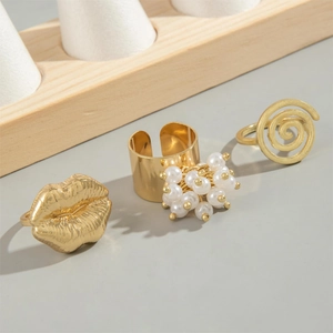 Retro gold ring set featuring textured lips, clusters of pearls, and spiral band designs