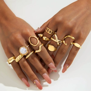 Set of gold irregular geometric rings with a large white pearl shown on model hands