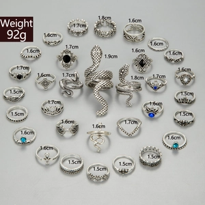 Flat lay of 28pcs vintage silver rings with snake, crown, and boho floral design details