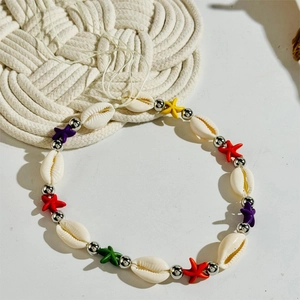Detailed shot of bohemian beach waist chain with white cowrie shells and colorful star beads