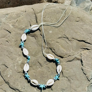 Detailed close-up of shell and starfish beads on a bohemian style beach body chain