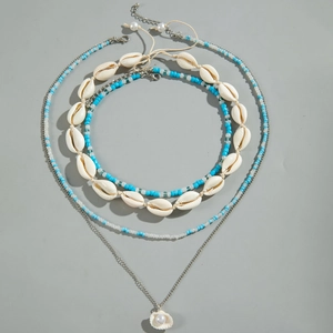 Détail de colliers bohèmes superposés avec coquillages naturels et perles turquoise