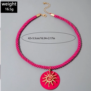 Detail showing hot pink braided cord necklace with a golden sun pendant and lobster clasp