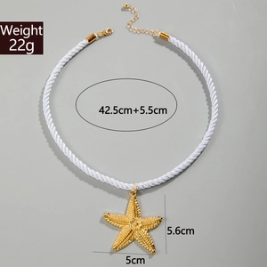 Detail of starfish pendant necklace with golden texture and white rope cord specs
