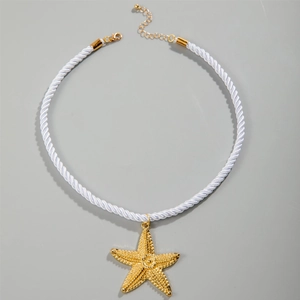 Detail of white braided cord necklace featuring a gold starfish pendant and lobster clasp