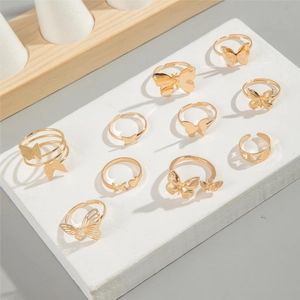 Ten-piece gold butterfly ring set with hollow and embossed designs on white pedestals