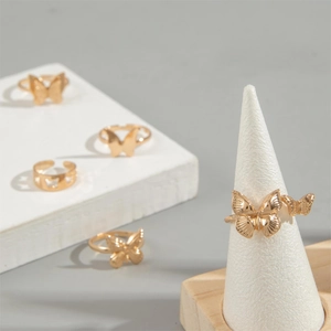 5-piece gold butterfly ring set featuring open adjustable designs on white jewelry stands