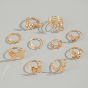 Ten-piece set of golden butterfly and heart shaped open rings for women on grey background