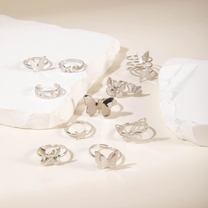 Detailed view of a silver butterfly and heart themed 10-piece stacked ring set