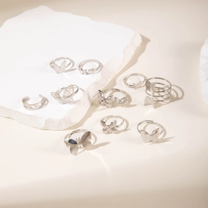 Detailed close-up of a silver butterfly ring set on a white stone background