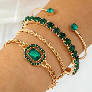 Gros plan d'un ensemble de 4 bracelets dorés avec cristaux vert émeraude brillants