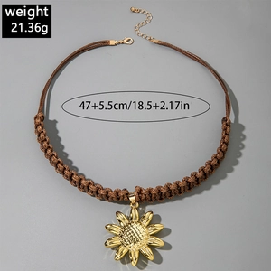Close-up of metallic sunflower pendant with brown braided cord and adjustable lobster clasp