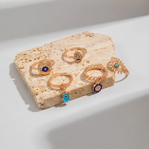 Détail de bagues dorées Hamsa et mauvais œil avec des pierres turquoises bleues