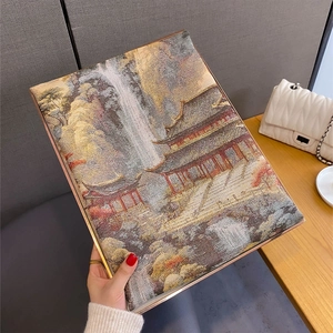Detailed view of an elegant landscape print scarf with metallic trim edges and artful design
