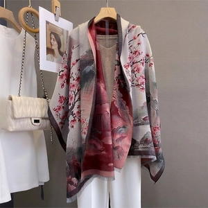 Détail d'une écharpe d'hiver avec imprimé floral et bords à pompons doux