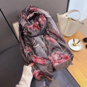 Détail d'une écharpe soyeuse avec motifs de pivoines roses et bords à franges doux