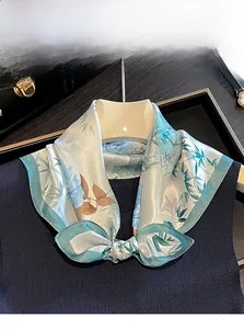 Detail of 100% mulberry silk scarf with floral prints worn as a stylish necktie knot