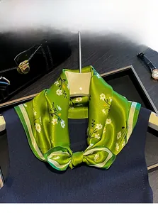 Dettaglio di sciarpa in 100% seta di gelso con stampa floreale verde e trama satinata