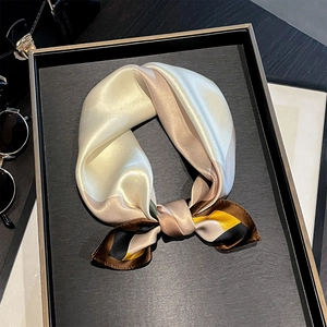 Dettaglio del foulard in seta stampata con motivi geometrici su un vassoio di lusso