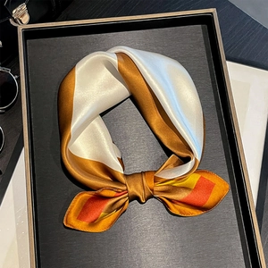 Dettaglio di un foulard quadrato in seta a fiocco con design geometrico colorblock moderno