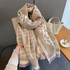 Dettaglio di morbida sciarpa in finto cashmere con stampa leopardata, quadri e frange