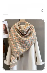 Detail of soft imitation cashmere scarf featuring geometric zigzag patterns and fringe trim