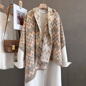 Thick autumn scarf with geometric wave pattern and fringe on a boutique wall display