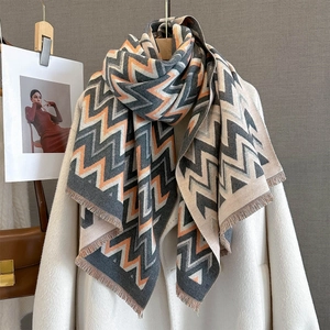 Thick autumn scarf with geometric zigzag stripes in blue, orange, and beige with tassels