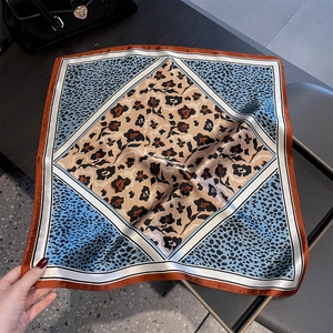 Detail of silk square scarf featuring leopard print patterns and geometric borders