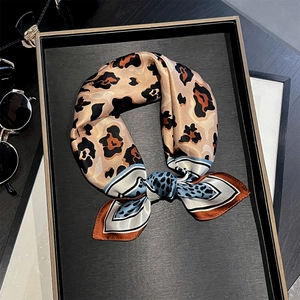 Detail of silk leopard print square scarf with contrast blue border in a bow shape