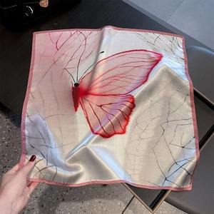Detail of silk scarf with red butterfly print and delicate pink stitched edges