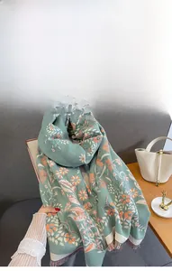 Close-up of soft imitation cashmere floral scarf in green with orange flower patterns