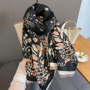 Detail of floral jacquard scarf with orange petals and delicate fringe edges