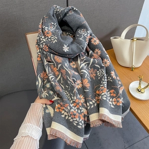 Close-up of grey and orange floral jacquard scarf with soft fringe detailing