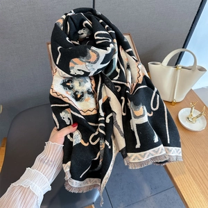 Detail of horse jacquard scarf with orange tassels and thick knit texture for winter