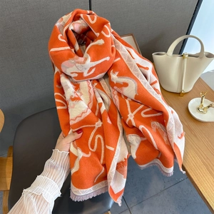 Macro shot of bright orange equestrian jacquard scarf with delicate fringe edges
