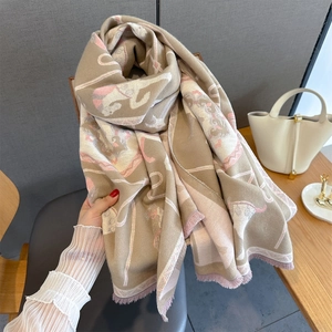 Close-up of animal jacquard scarf featuring horse patterns and pink fringe edges
