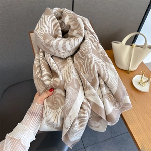 Close-up of zebra pattern scarf with fine tassel fringe on soft faux cashmere fabric