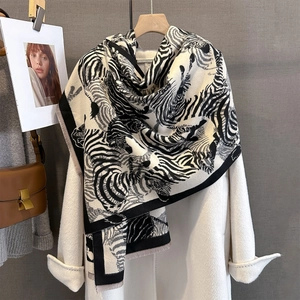 Detail view of zebra print cashmere-like shawl with thick texture and fringe edges